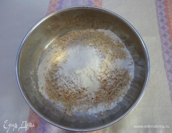 Муку соединить с мелко молотым миндалем и разрыхлителем. Шоколад с маслом растопить на водяной бане. Включить духовку на 180°C.