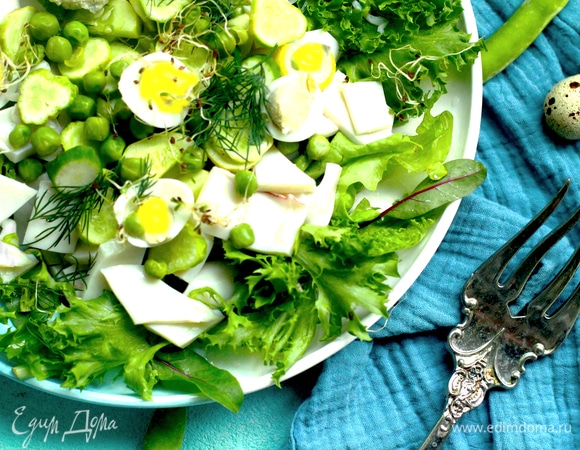 Выложить на блюдо салатный микс, огурец, сельдерей, кальмар и посыпать горошком.