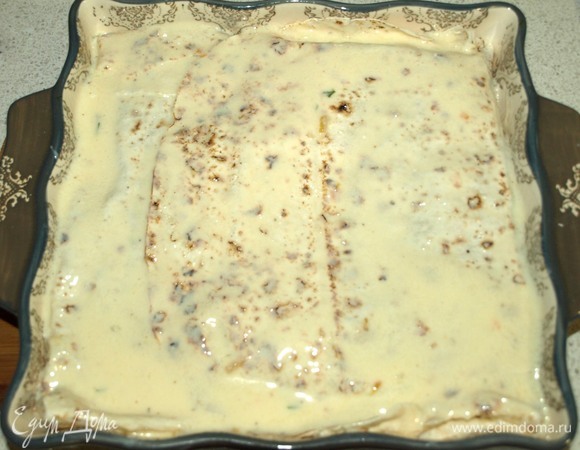 Закрываем вторым пластом лаваша. Сверху выливаем оставшуюся кефирную смесь и равномерно распределяем по всему верху пирога.