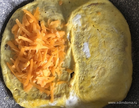 Как только яйца схватятся, переворачиваем хлеб с омлетом и сразу начинаем выкладывать начинку: у меня тертый сыр (можно взять плавленый сыр пластами).