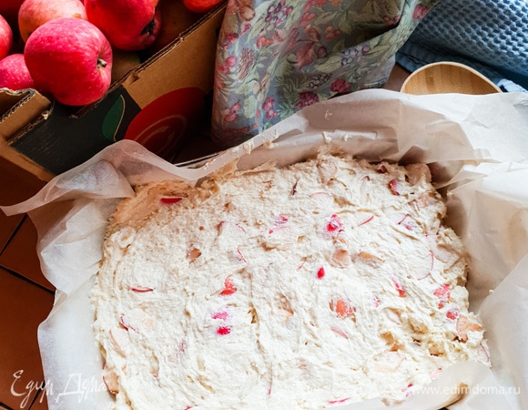 Добавить яблоки в тесто и перемешать. Застелить форму для выпечки пергаментом, выложить тесто и разровнять. Поставить форму с тестом в духовку и выпекать примерно 35 минут до сухой палочки.