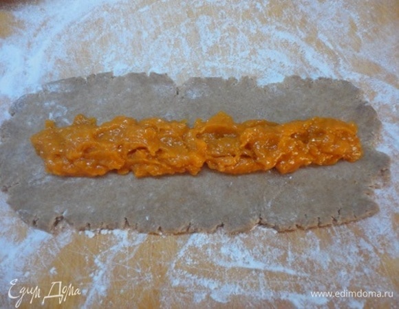 Готовое тесто разделите на три равные части. Каждую раскатайте в прямоугольник примерно 30 на 10 см. По центру выложите одну треть пасты и загните свободные от начинки края к центру.