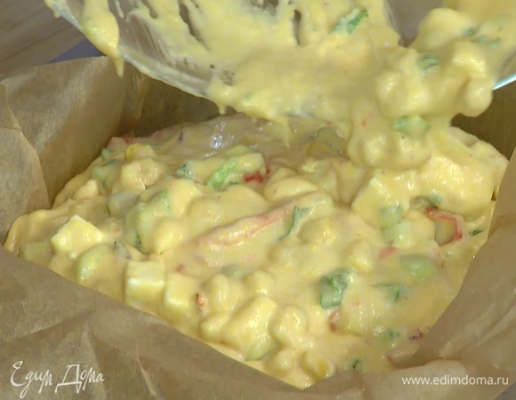 Форму для выпекания застелить бумагой для выпечки, выложить тесто, равномерно распределить и посыпать натертым сыром.