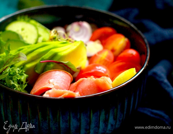 Рыбу нарезаем ломтиками. Авокадо очищаем и нарезаем тонкими пластинами. Черри нарезаем пополам, огурец — полудольками. Лук шинкуем полукольцами.