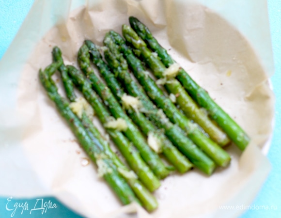 Разогреваем духовку до 200°C. Спаржу моем, очищаем и укладываем на противень на пергамент или фольгу. Равномерно поливаем смесью оливкового масла и мелко рубленного чеснока, посыпаем солью, перцем и запекаем в течение 15 минут.