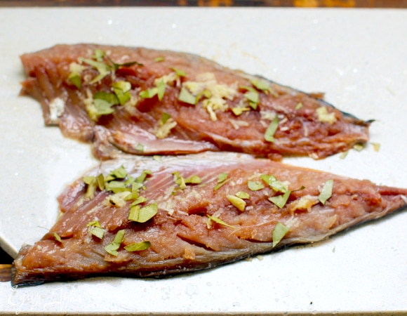 Далее в миску насыпаем соль (на мой вкус соли маловато, я бы добавила), сахар, черный молотый перец, кориандр и листики лаврушки. Все мелко раздробить, перемешать. Этой смесью натираем рыбу. Потом берем чеснок и пропускаем через пресс. Чесноком натираем филе рыбы.