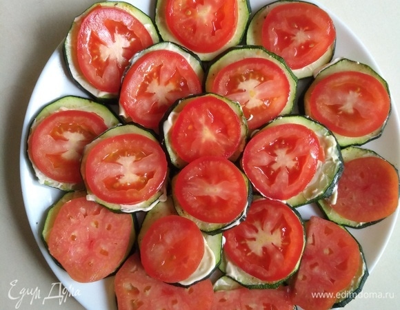 Сверху кладем помидоры. Их также смажем майонезом с чесноком.