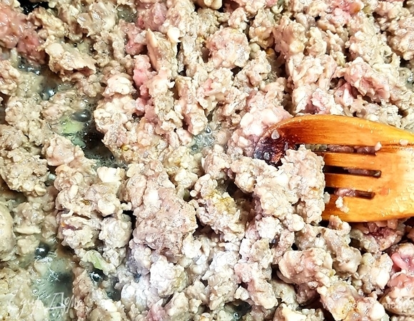 Разогреть сковороду с маслом и выложить в нее фарш. Обжаривать фарш до вытапливания жидкости, перемешивать,чтобы разбить комочки.