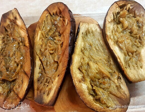 У запеченных баклажанов размять вилкой середину.