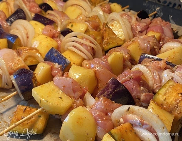 Духовку разогреть до 200°C, режим «Конвекция». Нанизать на шпажки мясо, чередуя с овощами и кольцами лука. Выложить на противень, застеленный пергаментом.