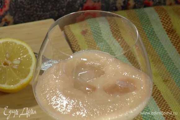 Охлажденные персики измельчить блендером в пюре и перелить в высокий бокал, добавить несколько кубиков льда.