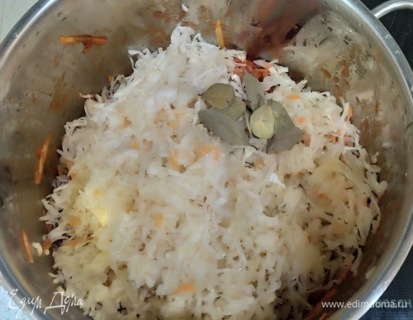 Выложить квашеную капусту и лавровый лист. Все перемешать, накрыть крышкой на 1–2 минуты.