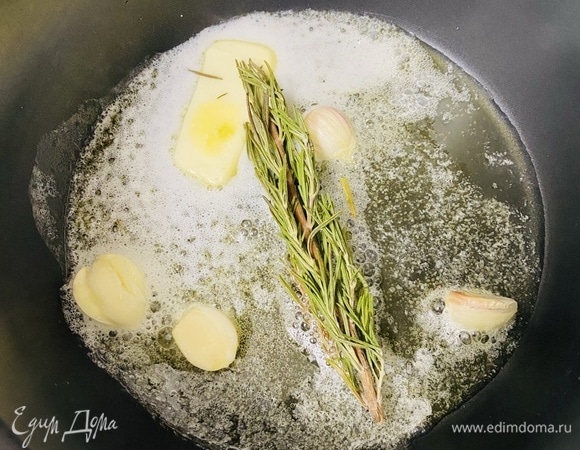 На сковороде разогреть сливочное и оливковое масло. Добавить раздавленные зубчики чеснока и веточку розмарина.