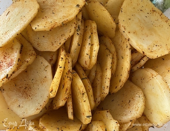 В миску сложить картофель, добавить все приправы (кроме соли). Полить оливковым маслом и все аккуратно перемешать.