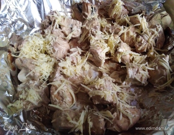 Форму для выпечки застелить фольгой. Выложить грибы с соусом. Посыпать натертым сыром.