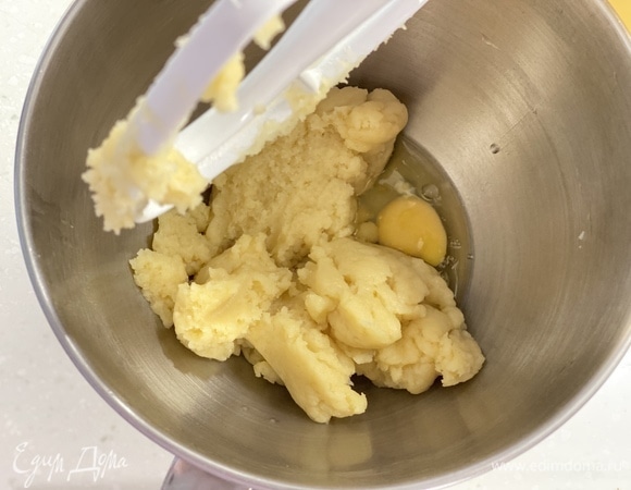 Переложить тесто в чашу миксера. Остудить в течение 2 минут. Перемешивая массу, постепенно добавлять по одному яйцу.