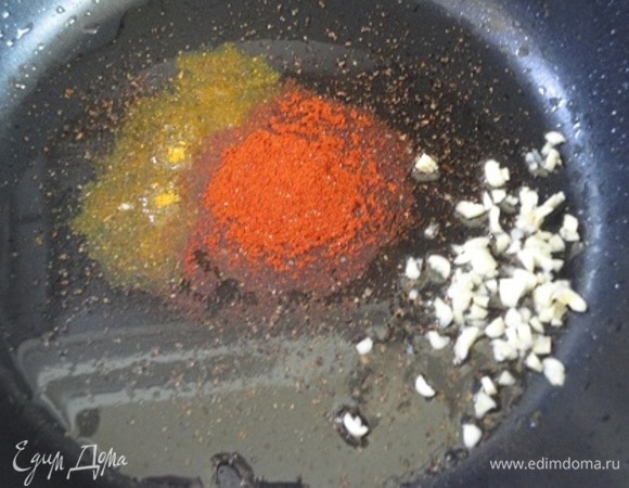 В холодную сковороду влить масло, добавить специи и чеснок. Включить нагрев. Когда масло хорошо нагреется, выложить мясо и жарить 10 минут, до золотистой корочки. Посолить.