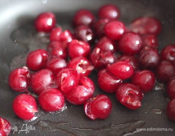Сковороду слегка смазываем сливочным маслом, выкладываем вишню, посыпаем сахаром и немного карамелизируем, пока она не станет чуть мягче, примерно 1–2 минуты.
