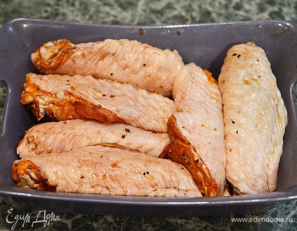 Выложите крылья в жаропрочную форму. Поставьте в заранее разогретую до 180°C духовку на 45–50 минут. В процессе запекания несколько раз смажьте крылышки с помощью кулинарной кисти маринадом прямо из формы.