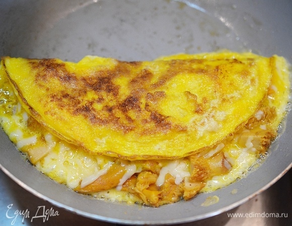 Накройте часть с начинкой второй половиной омлета и доведите до полной готовности, обжаривая с двух сторон.