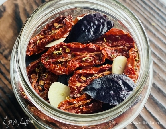 Готовые помидоры уложить в стерилизованные баночки (если хранение планируется длительное), чередуя их с тонкими дольками чеснока и листьями базилика.