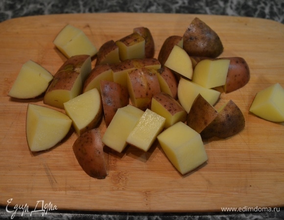 Картошку хорошо вымойте, ведь она будет готовиться в кожуре. Поэтому лучше воспользуйтесь специальной щеткой для мытья овощей. Нарежьте на кусочки размером около 1,5–2 см.