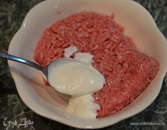 Пока запекается баклажан, займемся приготовлением начинки. К фаршу добавьте сметану (ее, кстати, можно заменить кефиром).