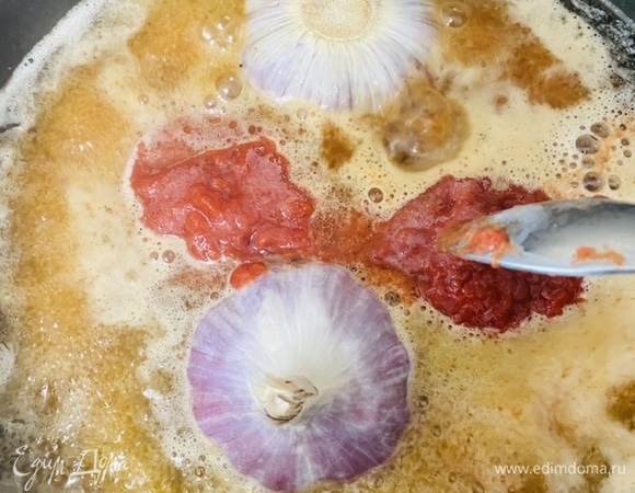 Сцеженный бульон поставить на средний огонь, добавить томатную пасту (я использовала свежесваренные пюрированные томаты). Перемешать до однородности. Большую головку чеснока разрезать поперек и положить в бульон. Закрыть крышкой и варить минут 10–15.