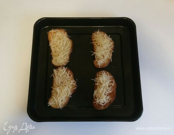 На противень положить натертый чесноком хлеб и обильно посыпать его сыром. Затем поставить противень в разогретую до 160°C духовку на 3–4 минуты, чтобы сыр расплавился (время приготовления зависит от вашей духовки).