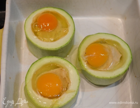 Выложите колечки в жаропрочную форму и аккуратно вбейте яйца. Запекайте в раогретой до 180°C духовке до желаемой консистенции яйца, но не менее 20 минут, чтобы фарш успел дойти до готовности.