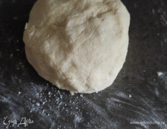 Добавляем муку и замешиваем тесто. Вымешивать сильно его не нужно, достаточно хорошо соединить все ингредиенты. Муки может понадобиться чуть больше или чуть меньше в зависимости от влажности творога. Тесто должно получиться воздушное, немного липкое. Не забивайте его мукой! Из теста формируем шар, помещаем в пищевую пленку и кладем в холодильник на 30 минут.