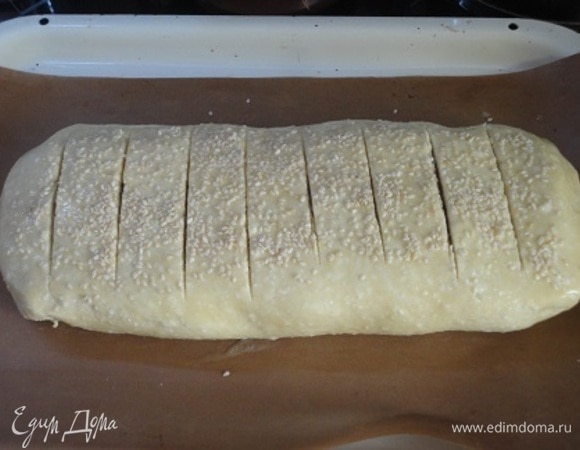 Смазать поверхность рулета яйцом, посыпать маком или кунжутом. Затем острым тонким ножом сделать поперечные разрезы на поверхности рулета с интервалами в 2–3 см.