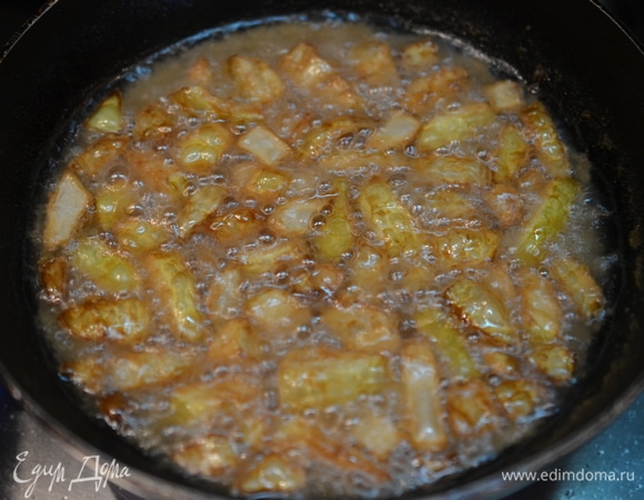 В сковороде разогрейте растительное масло, порциями обжаривайте запанированный лук до золотистого цвета и хрустящего состояния.
