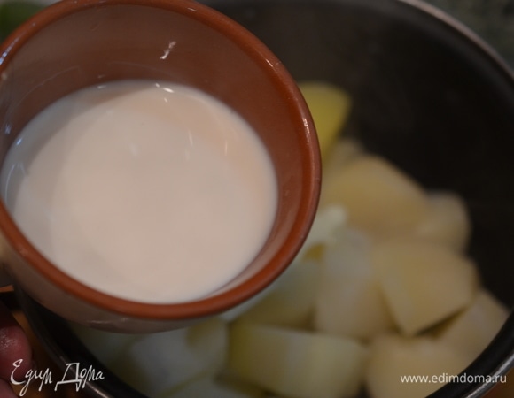 Когда картошка сварится, слейте воду. Добавьте сливочное масло и теплое молоко.