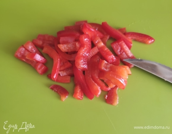 Красный болгарский перец режем все той же соломкой и добавляем к баклажанам.