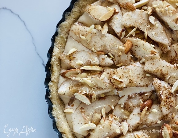 Достать форму, влить в нее заливку и выложить в 2 слоя дольки груши. Сверху посыпать нарезанным миндалем.