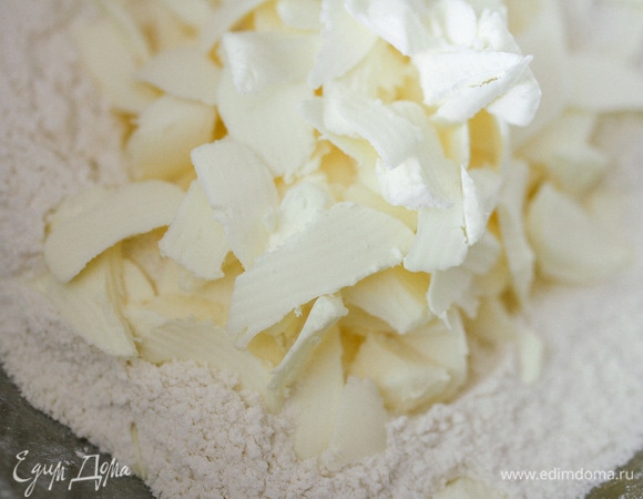 Муку просеять в миску, добавить сахар, соль, разрыхлитель. Ледяное сливочное масло нарезать на небольшие кусочки и перемешать с мучной смесью до получения мелкой крошки.
