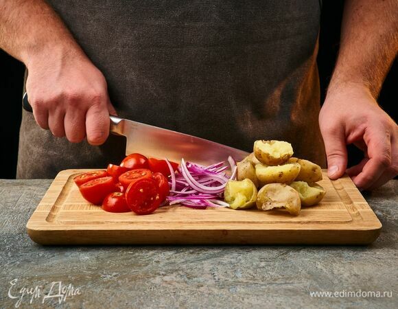 Помидоры черри и картофель разрежьте пополам, красный лук — перьями.