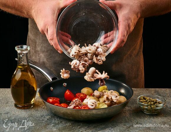 Выложите в сковороду с оливковым маслом осьминогов, помидоры черри, каперсы и картофель. Прогрейте 1–2 минуты. Затем выложите в салатник.