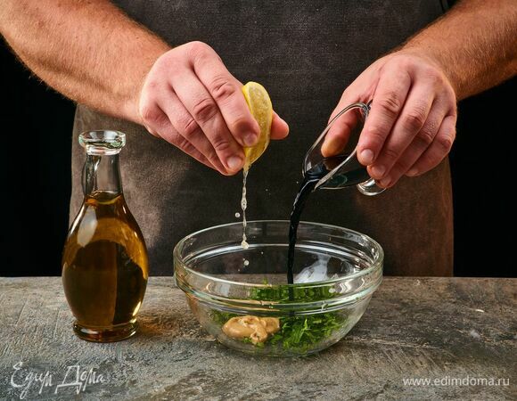 Приготовьте заправку. Измельчите петрушку и выложите в миску. Влейте уксус, оливковое масло, лимонный сок и добавьте горчицу. Перемешайте.