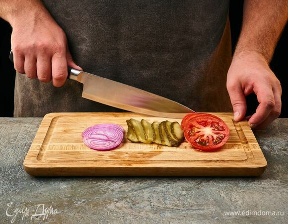 Нарежьте помидоры и лук кольцами, огурцы — тонкими пластинами.