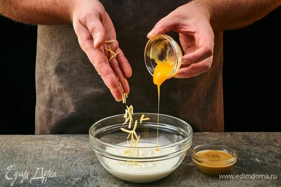 Приготовьте заливку. Соедините в чашке яичный желток и сливки. Добавьте горчицу, лимонную цедру.