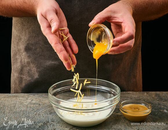 Приготовьте заливку. Соедините в чашке яичный желток и сливки. Добавьте горчицу, лимонную цедру.