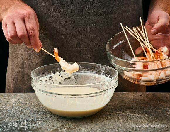 Креветки нанижите на шпажки,  а затем окуните в кляр.