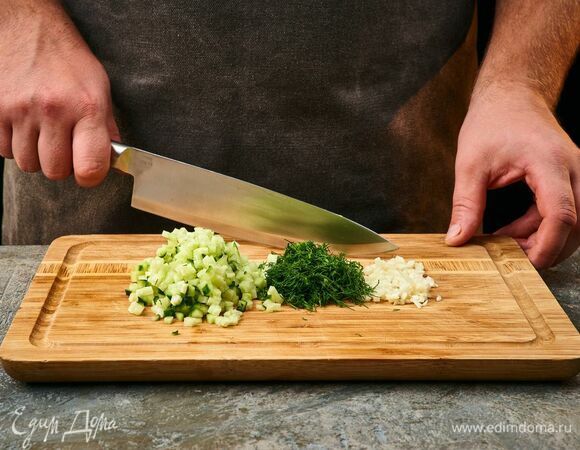 Приготовьте соус. Огурец мелко нарежьте. Чеснок и укроп мелко порубите.