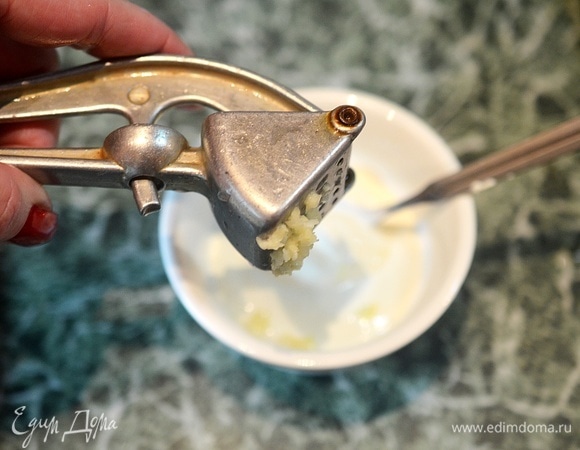 Сметану посолите, добавьте измельченный чеснок.