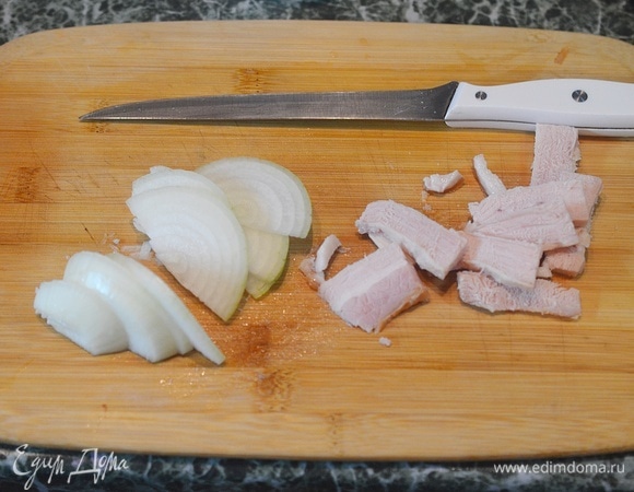 Лук почистите и нарежьте полукольцами, бекон или грудинку — небольшими кусочками. Можно использовать и копченый бекон, и охлажденный в виде свежего мяса.