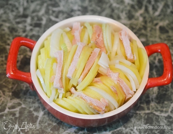 Между кружками картофеля разложите лук и бекон.