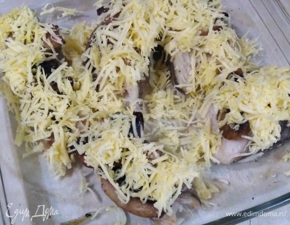 Обжаренную рыбу освободить от бумаги, выложить в огнеупорную посуду. Поверх рыбы — грибы. Посыпать натертым на мелкой терке сыром.