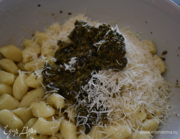 Добавьте в картофельные ньокки песто и натертый пармезан. Аккуратно все перемешайте.